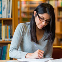 student writing in library
